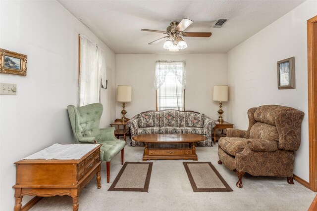 carpeted living room with ceiling fan