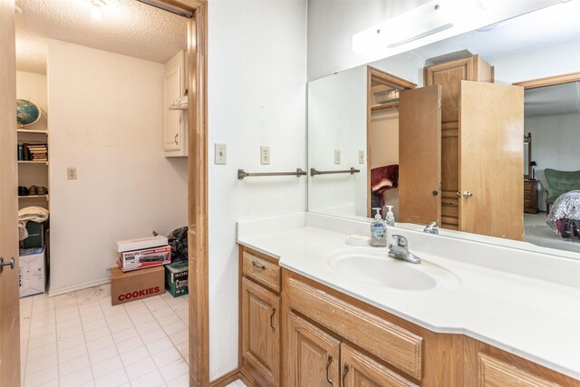 bathroom with vanity, tile patterned floors, and a textured ceiling