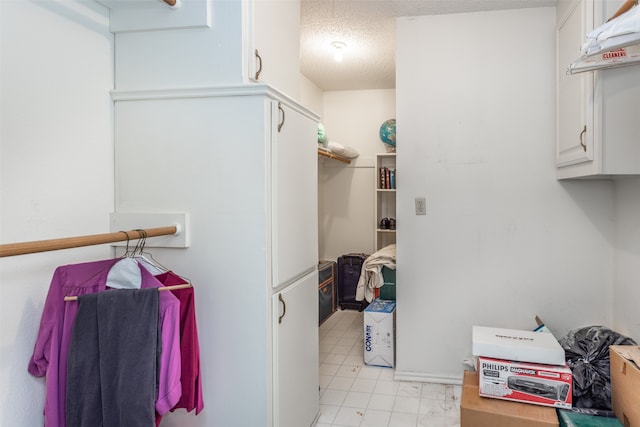 laundry room with light tile patterned flooring and a textured ceiling