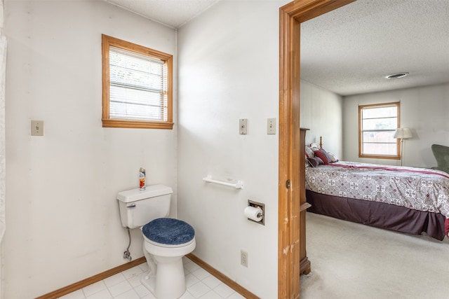 bathroom featuring tile patterned floors, toilet, and a textured ceiling