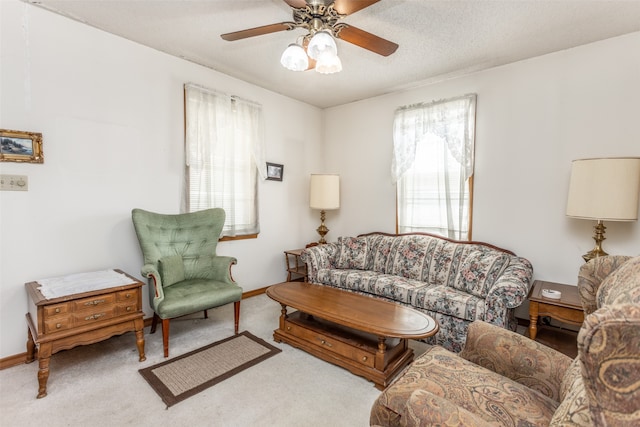 carpeted living room with a textured ceiling and ceiling fan