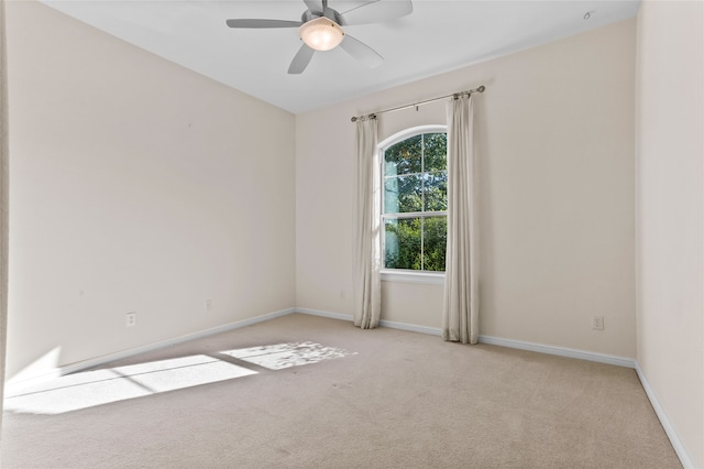 carpeted spare room with ceiling fan