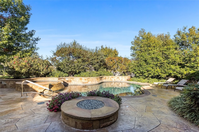 view of pool with a patio and an outdoor fire pit