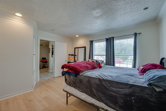 bedroom featuring light hardwood / wood-style flooring, a textured ceiling, and crown molding