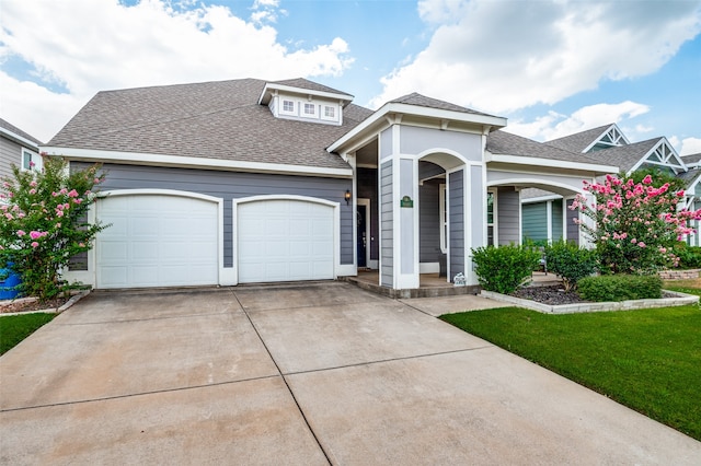 view of front of house featuring a garage and a front lawn