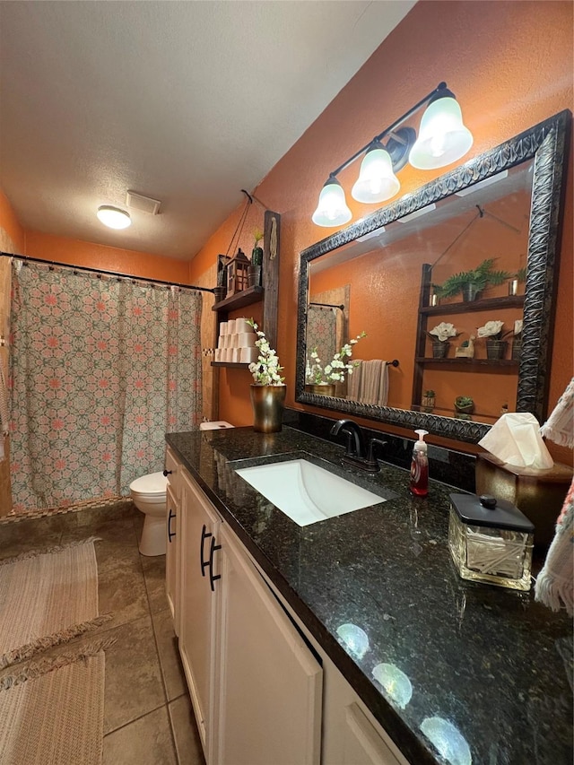 bathroom featuring vanity, tile patterned floors, a textured ceiling, and toilet