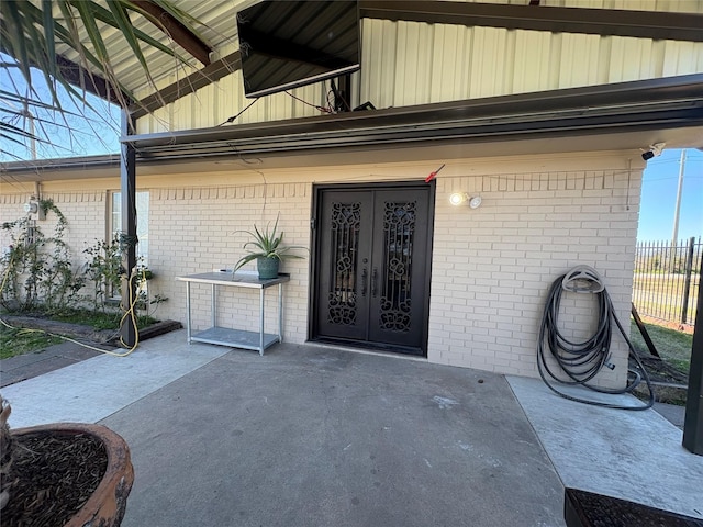 view of exterior entry with french doors and a patio area