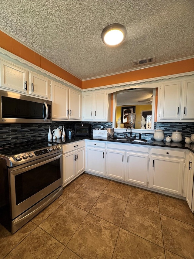 kitchen with stainless steel appliances, white cabinetry, sink, and tasteful backsplash