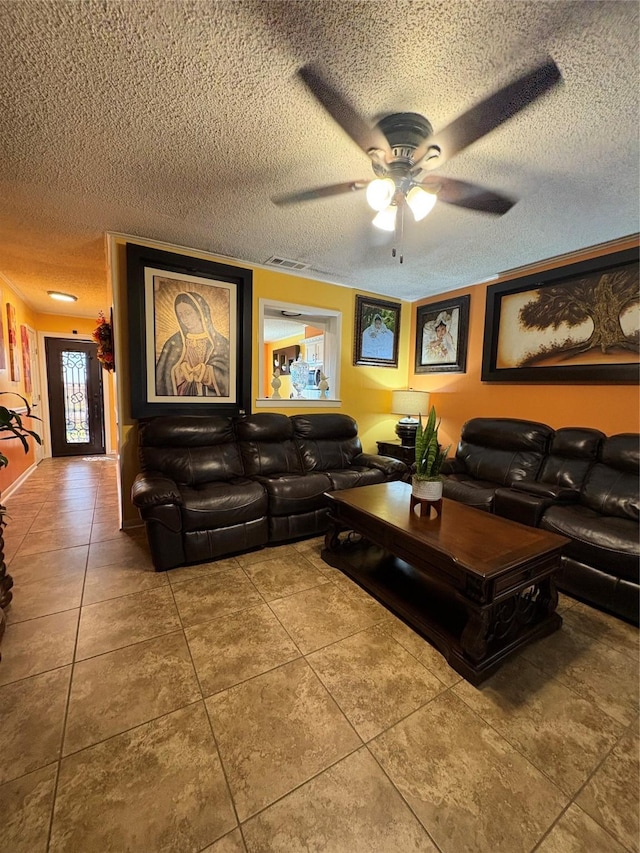 living room with ceiling fan, tile patterned floors, and a textured ceiling