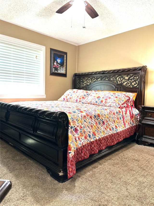 carpeted bedroom featuring ceiling fan and a textured ceiling