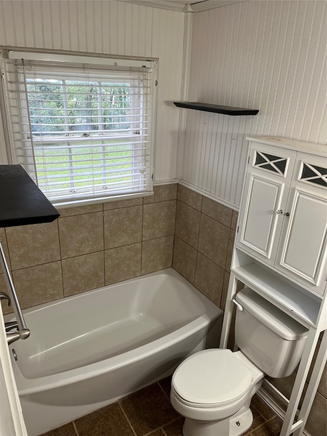 bathroom featuring a tub to relax in, tile patterned flooring, and toilet