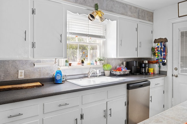 kitchen with stainless steel dishwasher, white cabinets, sink, and backsplash