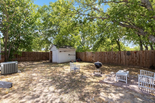 view of yard featuring a patio, central AC, and a storage shed