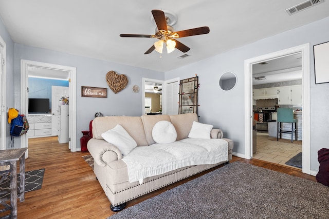 living room featuring light hardwood / wood-style floors and ceiling fan