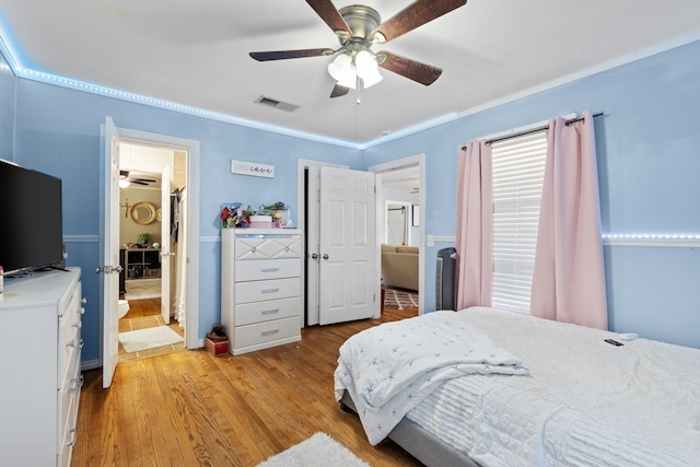 bedroom with ensuite bath, light hardwood / wood-style flooring, ceiling fan, and crown molding