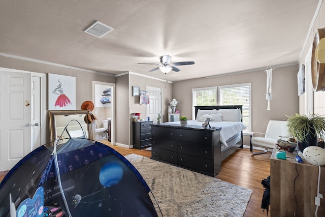 bedroom featuring hardwood / wood-style flooring, ceiling fan, and crown molding