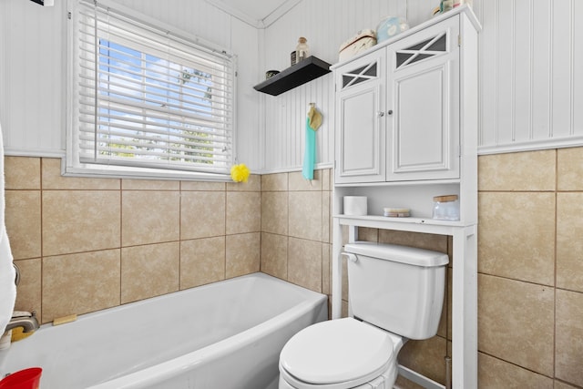 bathroom featuring toilet, a tub, and ornamental molding