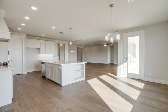 kitchen with white cabinetry, stainless steel dishwasher, a center island with sink, and sink