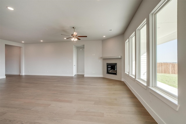 unfurnished living room with light hardwood / wood-style flooring and ceiling fan