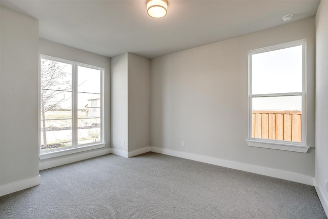 carpeted spare room featuring plenty of natural light