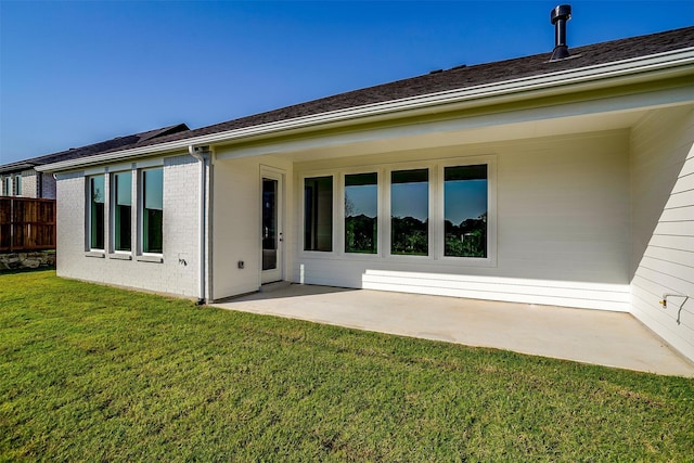 rear view of property with a patio and a lawn