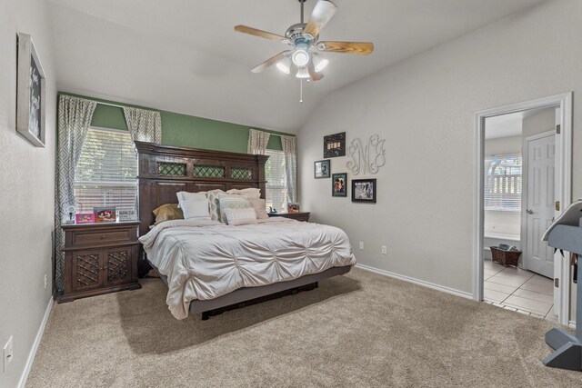 bedroom with connected bathroom, light tile patterned floors, lofted ceiling, and multiple windows