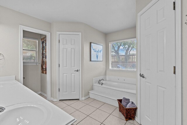 bathroom featuring tile patterned floors, vanity, and a washtub