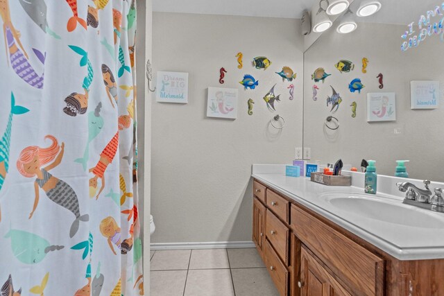 bathroom featuring toilet, vanity, and tile patterned flooring