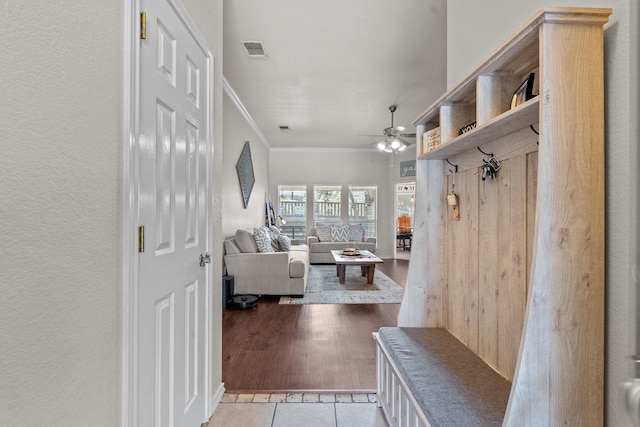 mudroom featuring ceiling fan, crown molding, and light wood-type flooring