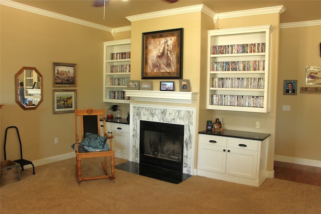 living room featuring carpet floors, a high end fireplace, ornamental molding, and built in shelves