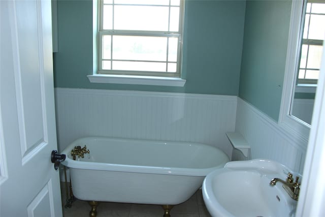 bathroom featuring a bath, sink, and tile patterned floors