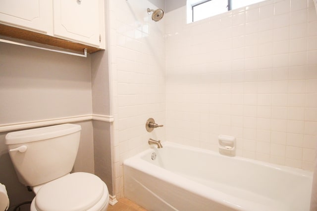 bathroom featuring toilet and tiled shower / bath