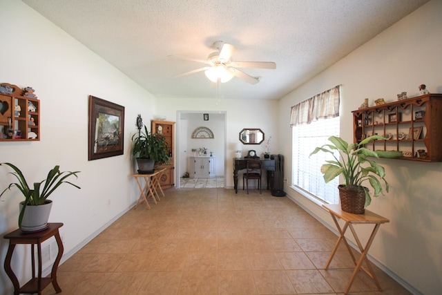 sitting room with light tile patterned flooring, a textured ceiling, and ceiling fan