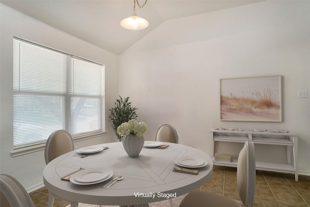 dining area featuring vaulted ceiling, baseboards, and tile patterned floors