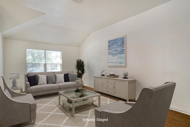 living area with baseboards, wood finished floors, and vaulted ceiling