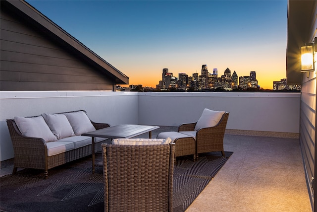 patio terrace at dusk featuring a balcony and an outdoor hangout area