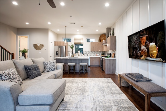 living room featuring ceiling fan and dark hardwood / wood-style flooring