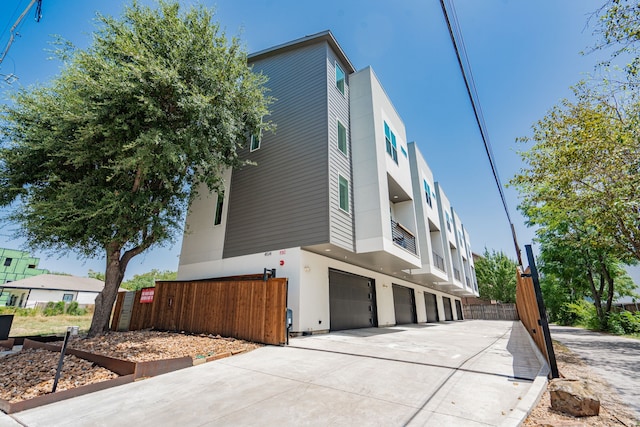 view of side of property featuring a balcony and a garage