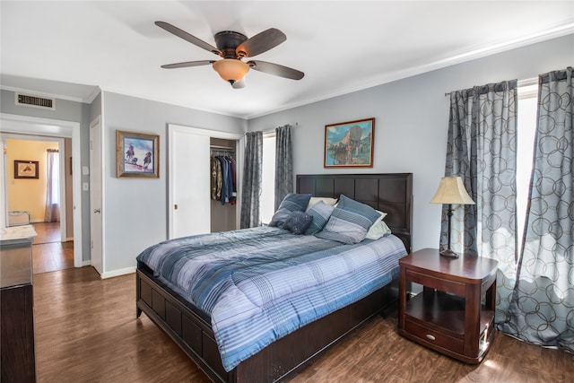 bedroom with ceiling fan, dark hardwood / wood-style flooring, multiple windows, and a closet