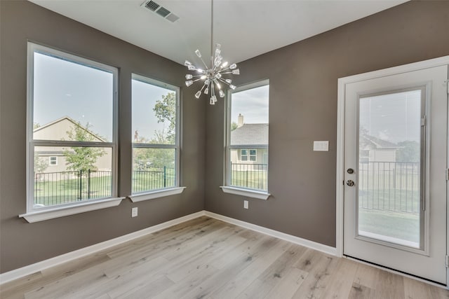 interior space with light hardwood / wood-style floors and an inviting chandelier