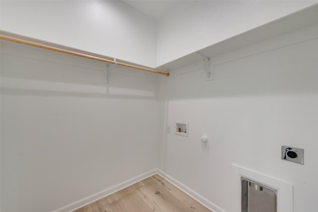 clothes washing area with hookup for a washing machine, electric dryer hookup, light wood-type flooring, and hookup for a gas dryer