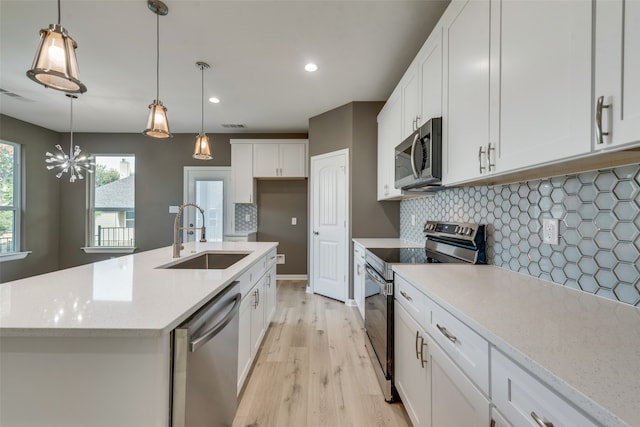 kitchen with white cabinetry, tasteful backsplash, light hardwood / wood-style floors, appliances with stainless steel finishes, and sink