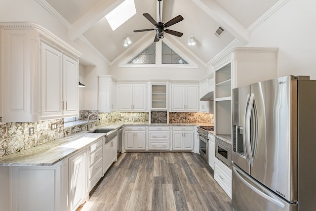 kitchen featuring a skylight, crown molding, hardwood / wood-style floors, appliances with stainless steel finishes, and sink