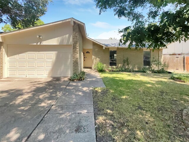 ranch-style house with a garage and a front lawn