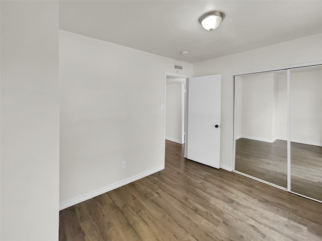 unfurnished bedroom with hardwood / wood-style flooring and a closet