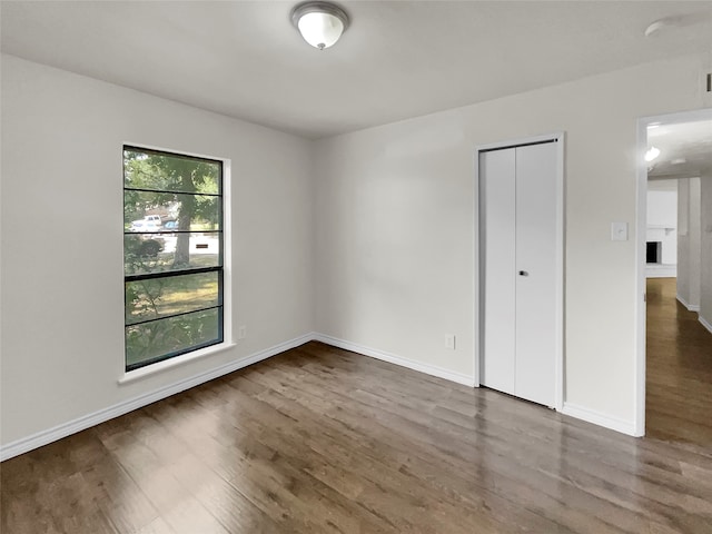 empty room with hardwood / wood-style floors and a wealth of natural light