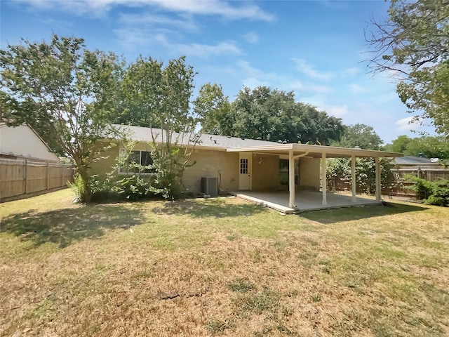 rear view of property featuring a patio, a lawn, and central AC