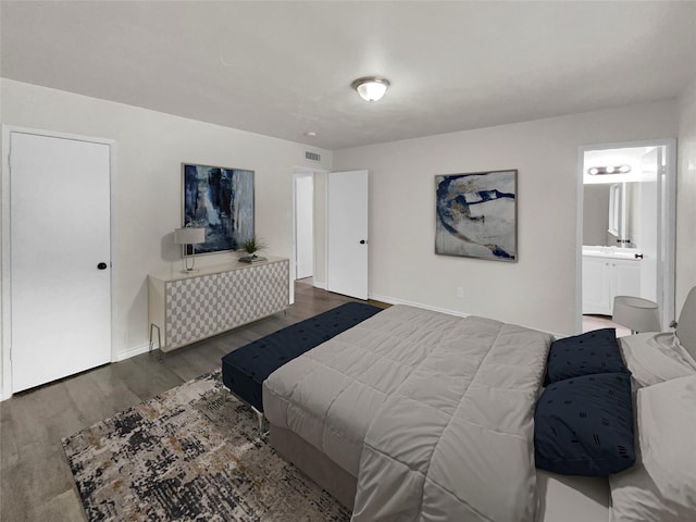 bedroom with dark hardwood / wood-style flooring and connected bathroom