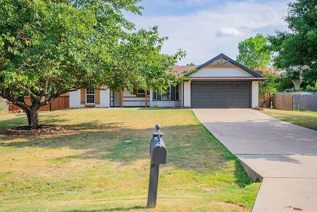 view of property hidden behind natural elements with a garage and a front yard