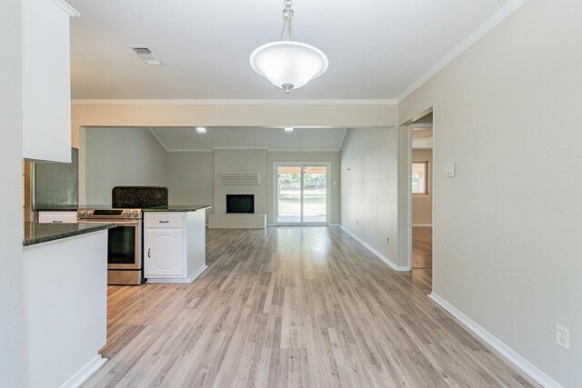 kitchen with white cabinetry, a brick fireplace, light hardwood / wood-style floors, and decorative light fixtures